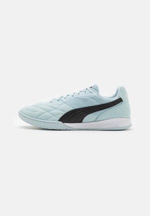 Lichtblauwe sportieve schoen met een gestructureerde bovenkant, zwarte accenten en een gladde witte rubberen zool. Geknoopt ontwerp met een gevoerde kraag.