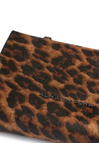 Portafoglio a stampa leopardata realizzato in materiale testurizzato marrone e nero, con testo embossato "ALMA EN PENA" lungo il bordo inferiore.