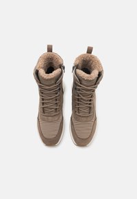 Bottines marron avec un intérieur doux et doublé de fourrure, un extérieur en daim et synthétique, des lacets ajustables et des zips latéraux pour un enfilage facile.