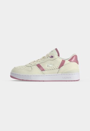 Baskets basses crème avec des accents roses, semelle blanche, logo Lacoste sur le côté et le talon, et détails perforés le long de la tige.