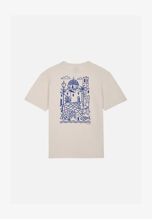 Beige T-shirt met blauwe lijntekening van mediterrane gebouwen, palmbomen, straatlantaarn en een vis vlakbij golvend water achter in het midden.