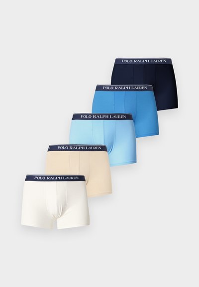 Cinq paires de boxers pour hommes en blanc, beige, bleu clair, bleu moyen et marine avec des ceintures Polo Ralph Lauren.