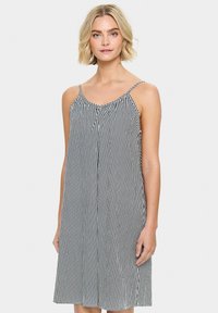 Rochie fără mâneci, cu dungi alb-negru, cu o croială lejeră, gât strâns, bretele subțiri și se termină deasupra genunchiului.