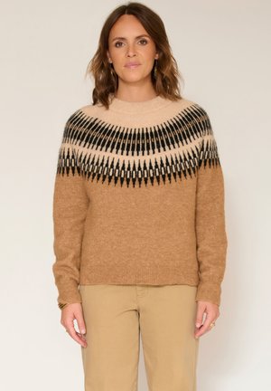 Pull en tricot beige à col montant, avec un motif géométrique noir et crème sur l'empiècement. Finition douce et texturée.