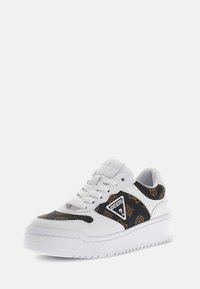 Sneaker bianco con un motivo a logo testurizzato in nero e oro. Presenta una linguetta imbottita, accenti del logo e una suola bianca spessa.