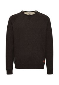 Sweat-shirt à col rond marron foncé avec des manches raglan, en tissu texturé, et un petit patch de marque dans le coin inférieur gauche.