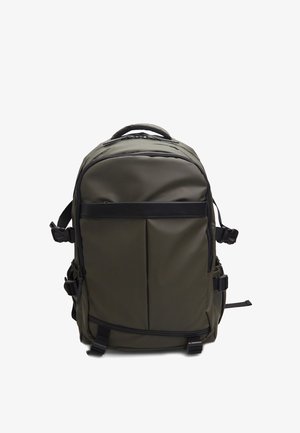 Olíva zöld hátizsák sima, tartós anyagból. Állítható vállpántokkal, cipzáras rekeszekkel és letisztult, minimalista dizájnnal rendelkezik.