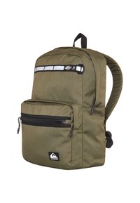 Mochila verde oliva fabricada con tejido duradero. Cuenta con un bolsillo frontal con cremallera, una franja reflectante y correas de hombro acolchadas. Logo mostrado en la parte inferior.
