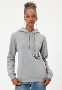 Sudadera gris de material suave con bolsillo tipo canguro, que presenta una ilustración impresa de un perro en el bolsillo y capucha con cordón.