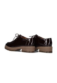 Chaussures en cuir verni noir avec bouts ronds, design à lacets et semelles épaisses marron présentant des rainures texturées pour une bonne adhérence.