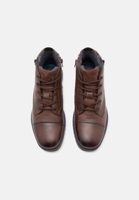 Botine din piele maronie, cu accente din suede texturat, sistem de prindere cu șireturi în față și fermoare pe laterale. Prezintă un finisaj neted și guleruri căptușite.