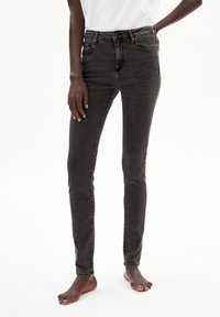Schwarze, schmale Jeans aus Denim mit mittelhoher Taille, subtilen Verwaschungen, Gesäßtaschen und einem klassischen Fünf-Taschen-Design.