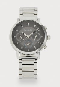 Montre en acier inoxydable argenté avec un cadran texturé gris foncé, trois sous-cadrans et un bracelet en maillons métalliques. Les caractéristiques incluent des indications de date et de jour.
