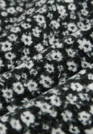 Juodas audinys su tekstūru, puikiai matomas balti gėlių raštai. Dizainas sudarytas iš mažų, išsibarstų gėlių ir subtilaus šešėliavimo.