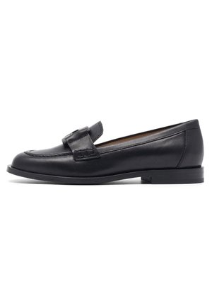 Mocasín de cuero negro con punta redondeada, detalles cosidos, una correa decorativa en la parte delantera y un tacón bajo apilado.