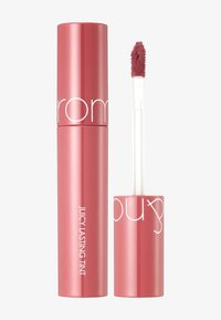 Tube de teinture à lèvres cylindrique rose avec une finition brillante. Présente un applicateur clair et effilé. Le texte inclut "JUICY LASTING TINT."