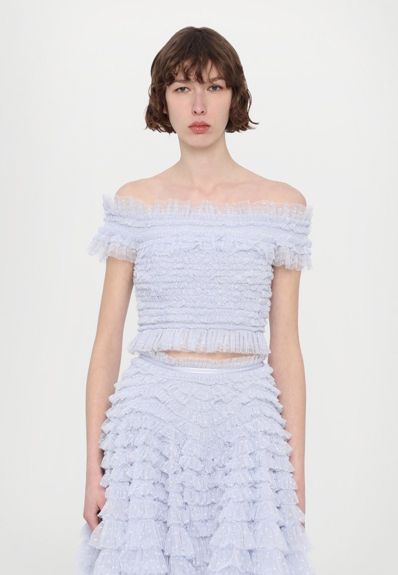 Top azzurro chiaro off-the-shoulder con volant testurizzati e gonna a strati coordinata, caratterizzata da motivi sottili e una vita aderente.