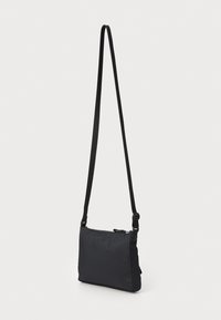 Sac bandoulière noir avec bandoulière réglable, fabriqué en matériau en tissu lisse, avec fermeture éclair et forme rectangulaire.