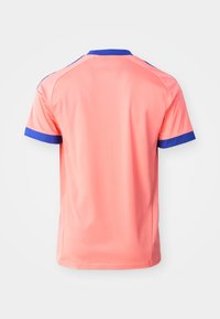 Športna majica s kratkimi rokavi koralno roza barve z modrim ovratnikom in manšetami, prikazana od zadaj na belem ozadju.