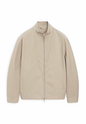 Giacca leggera beige con vestibilità dritta, colletto alto e chiusura frontale con zip; presenta due tasche laterali e una trama del tessuto liscia.