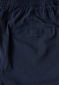 Shorts bleu marine en tissu léger, dotés d'une taille élastique, d'une texture lisse et d'une poche arrière avec un détail cousu.