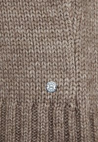 Berretto lavorato a maglia marrone con una consistenza a coste spesse e un'etichetta con il logo Mavi Denim in argento, realizzato in un morbido e caldo materiale in misto lana.