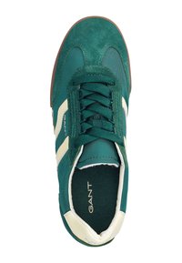Zelené semišové a textilní tenisky s bílými akcenty, vybavené šněrováním, polstrovaným límcem a hnědou gumovou podrážkou. Viditelné značkové jméno "GANT".
