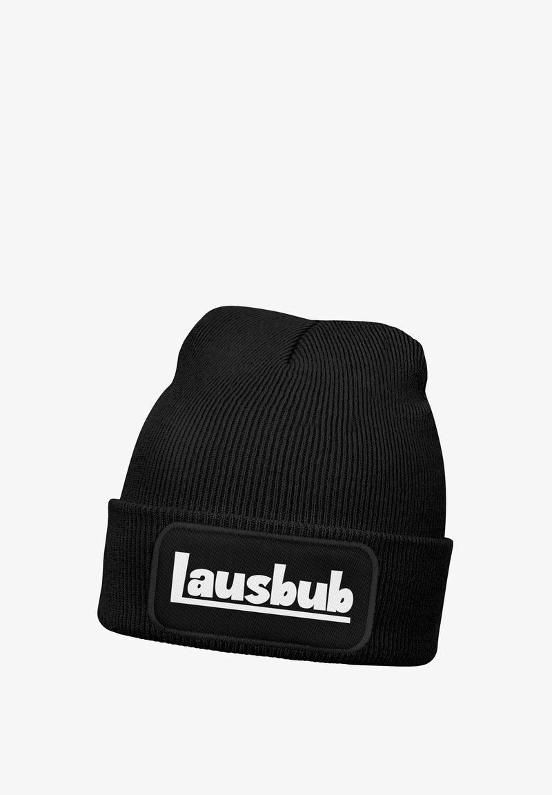 Schwarze Strickmütze mit geripptem Muster und umgeschlagenem Bündchen. Verziert mit einem rechteckigen Aufnäher, auf dem in Weiß "Lausbub" steht.