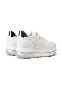 Sneakers bianchi in pelle con un accento lucido neri sul tallone e dettagli texture, con una suola piattaforma spessa rifinita in argento.