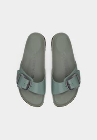 Πράσινα λαστιχένια σανδάλια με ένα ρυθμιζόμενο λουρί και ασημένια αγκράφα. Υφή στο πέλμα και λεία σόλα, με ετικέτα μεγέθους και μάρκας.