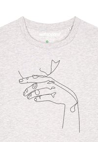 T-shirt en coton gris avec un dessin en ligne noire d'une main et d'un petit poisson, avec une texture douce et un col rond.