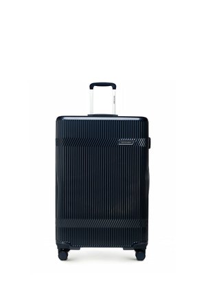 Czarna walizka z twardą skorupą z pionowymi żebrowaniami, wysuwanym uchwytem, czterema kółkami i nazwą marki "WITTCHEN" na przednim panelu.