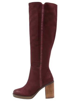 Wysokie damskie kozaki z ciemnogranatowego zamszu o ciemnej bordo barwie, z grubym drewnianym słupkowym obcasem i pionową teksturowaną lamówką wzdłuż boku.