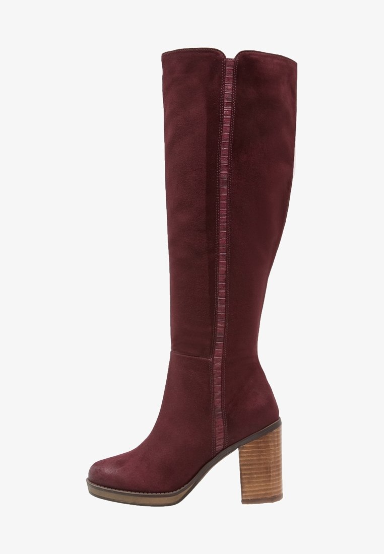 Botte haute pour femme en daim bordeaux foncé avec un talon bloc en bois empilé et une bande verticale texturée sur le côté.