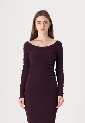 Long-sleeve, fitted dress in deep purple fabric with a soft texture. Features a wide boat neckline and subtle side ruching.