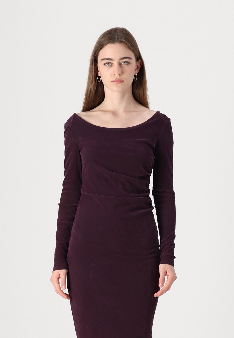 Long-sleeve, fitted dress in deep purple fabric with a soft texture. Features a wide boat neckline and subtle side ruching.