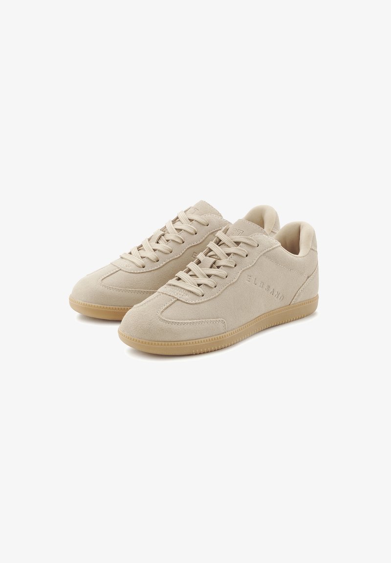 Beige suede sneakers with a low-top design, textured upper, lace closure, and a light brown rubber sole. Features subtle branding on the side.