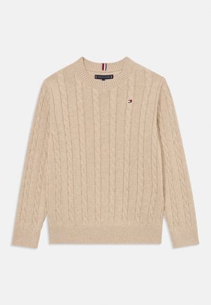 Beige kabelstrikket genser med ribbestrikket rund hals og mansjetter. Har en liten brodert logo på brystet. Teksturert, mykt stoff.