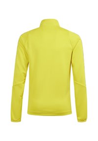 Giacca gialla a maniche lunghe con colletto alto, realizzata in un materiale leggero e liscio. Presenta dettagli laterali neri e una vestibilità rilassata.