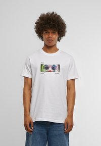 Hvid bomulds T-shirt med en farverig trykt grafik på forsiden, der forestiller et ansigt, med korte ærmer og rund halsudskæring.