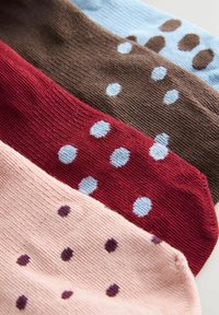 Négy pár zokni kék, barna, piros és rózsaszín színekben, mindegyiken kontrasztos pöttyös mintával a szöveten.