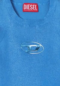 Maglione blu a coste con accenti metallici, caratterizzato da un ampio logo ovale in metallo argentato sul lato sinistro e una scollatura rotonda.