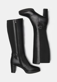 Black knee-high boots featuring a combination of smooth leather and textured fabric, with a high block heel and side zippers for easy wear.