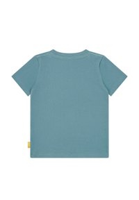 Korte mouwen t-shirt in gedempt blauw. Glad katoenen stof met een ronde hals. Bevat subtiele stiksels en een klein gele label aan de zoom.
