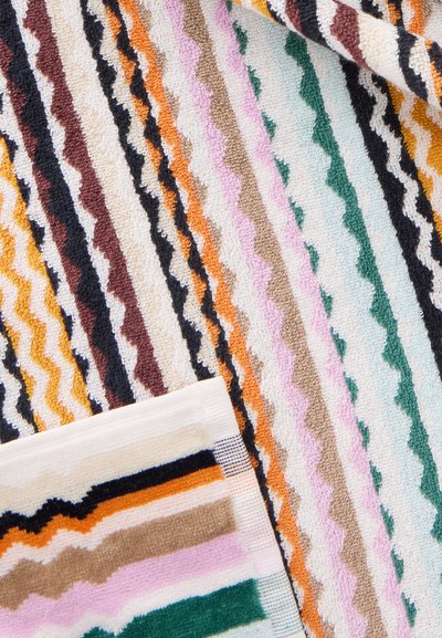 Tissu éponge coloré avec des rayures diagonales ondulées en orange, vert, rose, noir, marron et blanc.