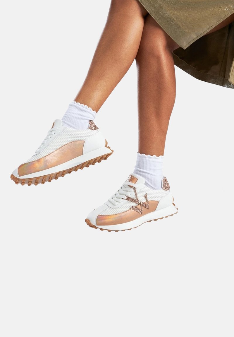 Baskets blanches et métalliques en matériau mesh et synthétique, avec une semelle texturée, des accents iridescents et des détails en paillettes.