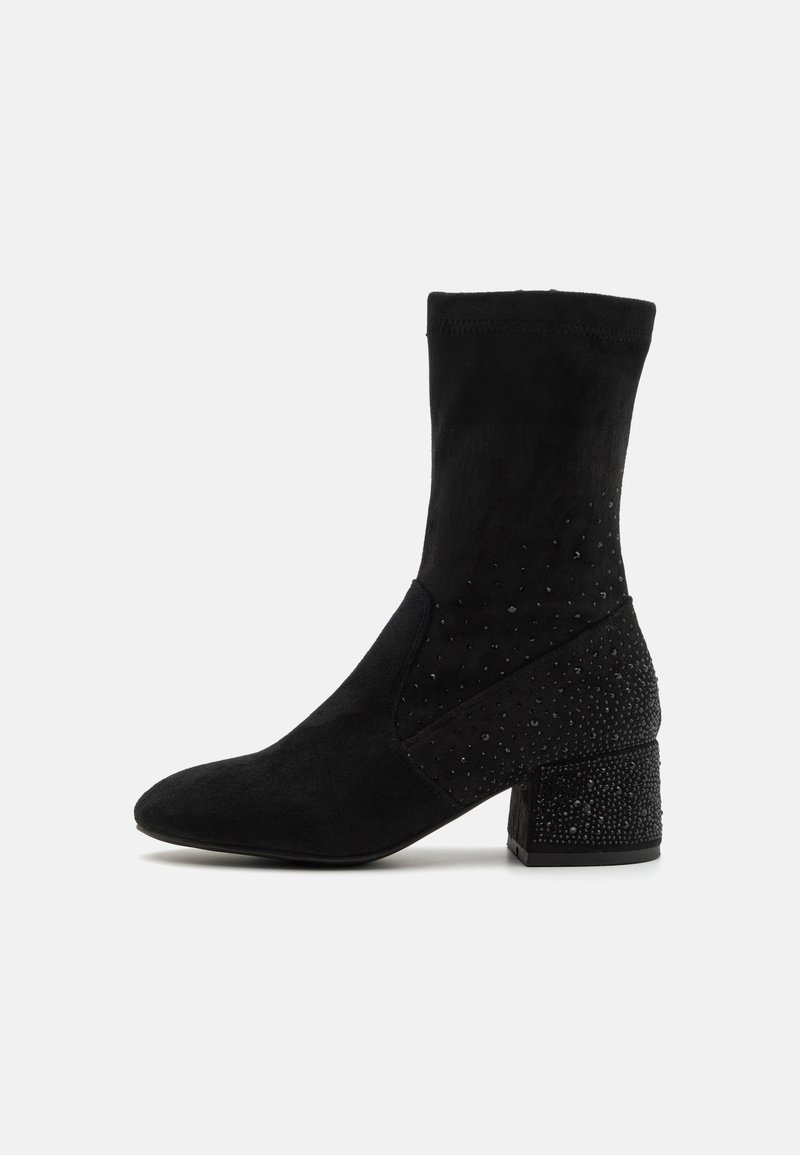 Bottines noires en suède souple avec un talon texturé orné de petites gemmes noires, présentant un design élégant et pointu.
