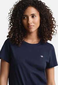 Navy blue short-sleeve T-shirt in soft cotton, featuring a small logo on the chest. Classic round neckline and relaxed fit.