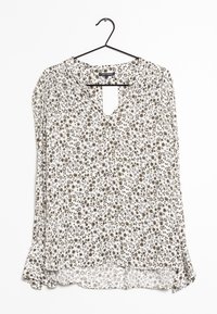 Camicia bianca a maniche lunghe con motivo floreale in marrone e nero. Collo a V e orlo arricciato. Tessuto leggero.
