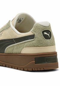 Scarpa da ginnastica beige e verde con sovrapposizioni in suede e materiale sintetico, caratterizzata da una parte posteriore texturizzata, suola in gomma e logo Puma sul tallone.